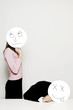 Business people holding cardboard cutout with facial expression.