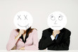 Business people holding cardboard cutout with facial expression.