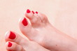woman feet with red toenails on towel
