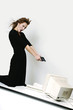 Businesswoman pointing her pistol at a computer monitor.