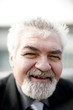 Senior businessman smiling at the camera.