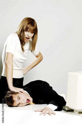 Photo: Businesswoman pressing her colleague's face against the table. Businesswoman pressing her colleague's face against the table.