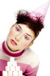 Woman in party hat posing in front of a stack of marshmallows.