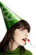Woman in party hat eating cherry.