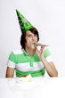 Man in party hat blowing a blowout.