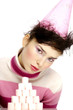 Woman in party hat posing in front of a stack of marshmallows.
