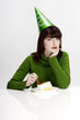 Woman in party hat eating cake.