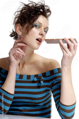Photo: Woman eating a bar of chocolate. Woman eating a bar of chocolate.