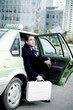 Photo: Businessman getting out from a taxi. Businessman getting out from a taxi.