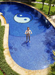 Foto: Woman practising yoga in the swimming pool. Woman practising yoga in the swimming pool.