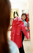 Foto: Mirror reflection of a woman trying out a trench coat. Mirror reflection of a woman trying out a trench coat.