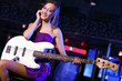 Young guitar player performing in night club