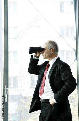 Photo: Businessman using binoculars. Businessman using binoculars.