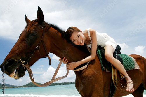 Photo: Woman horse riding on the beach. Woman horse riding on the beach.