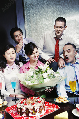 Foto: Woman receiving a bouquet of flowers as a birthday gift. Woman receiving a bouquet of flowers as a birthday gift.