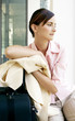 Businesswoman leaning on her travelling bag.