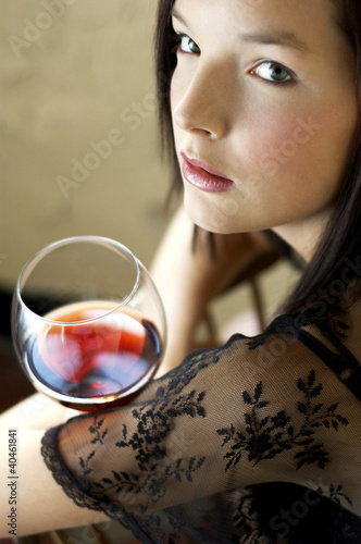 Photo: Woman holding a glass of red wine. Woman holding a glass of red wine.