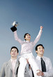 Businessmen lifting up a female winner.