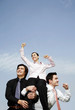 Businessmen lifting up the female winner.