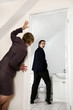Businesswoman peeping her male colleague in the toilet.