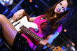 Young guitar player performing in night club