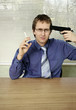 Photo: Businessman pointing a gun at himself while smoking cigarette. Businessman pointing a gun at himself while smoking cigarette.