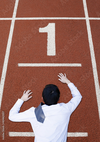 Foto: Businessman crawling on the running track. Businessman crawling on the running track.