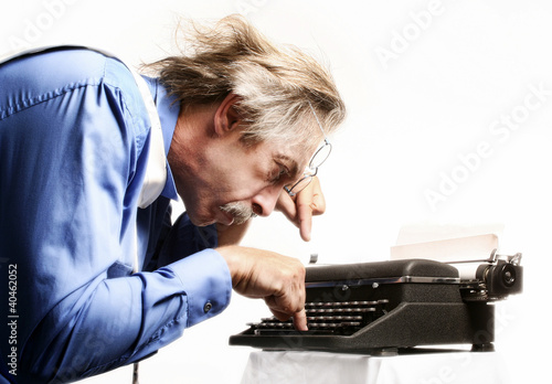 Photo: Businessman using a typewriter. Businessman using a typewriter.