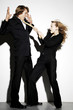 Businesswoman pulling a businessman's tie.