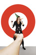 Foto: Hand aiming a pistol at a businesswoman with party hat. Hand aiming a pistol at a businesswoman with party hat.