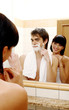 Woman watching her husband shaving.