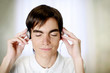 Man closing his eyes while listening to music on the headphones.
