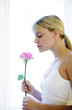 Woman smelling flower.