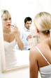 Man watching his wife applying lipstick.