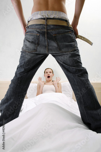 Photo: Man taking off his pants shocking his wife. Man taking off his pants shocking his wife.