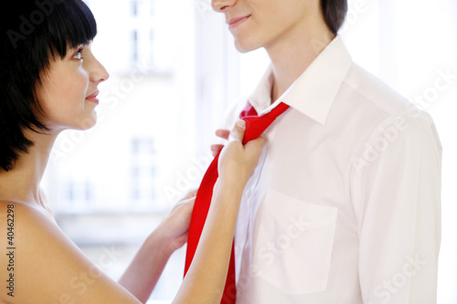 Foto: Woman adjusting her husband's tie. Woman adjusting her husband's tie.