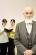 Old professor with his students having discussion on the background.