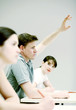 Photo: Man raising his hand to answer question. Man raising his hand to answer question.