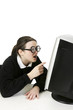 Girl with thick glasses using computer desktop.