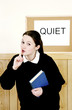 School girl showing a hushing sign.