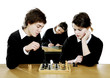 Boy and girl playing chess game in the classroom.