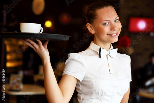 Photo: Portrait of young waitress holding a tray Portrait of young waitress holding a tray
