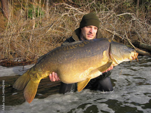 Photo: pêcheur heureux tenant une grosse carpe miroir pêcheur heureux tenant une grosse carpe miroir