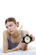 Woman getting frustrated with her alarm clock.