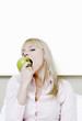 Photo: Businesswoman biting a green apple. Businesswoman biting a green apple.