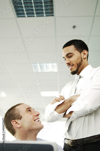 Photo: Two businessmen talking and smiling. Two businessmen talking and smiling.