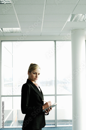 Foto: Businesswoman writing on her organizer. Businesswoman writing on her organizer.