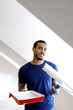 Man holding a paint roller and a paint tray.