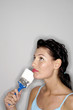 Foto: Woman holding a paint brush thinking. Woman holding a paint brush thinking.