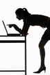 Silhouette of businesswoman using laptop.